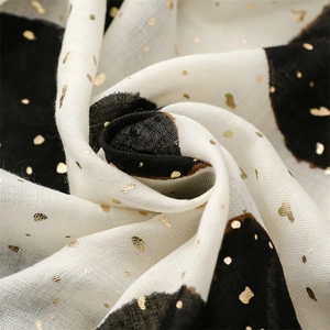 Detail of soft black and white cotton linen scarf with elegant gold foil dot patterns