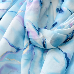 Detail of marble watercolor scarf with gold foil trim and lightweight fabric texture