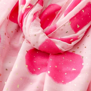 Macro detail of pink cotton-linen scarf featuring gold foil dots and burgundy polka patterns