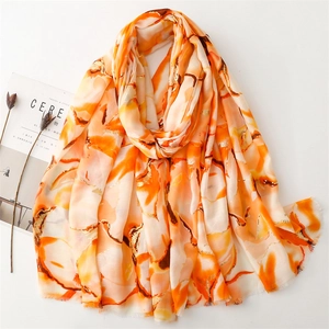 Detail of cotton linen scarf with gold foil floral patterns and soft fringe edges