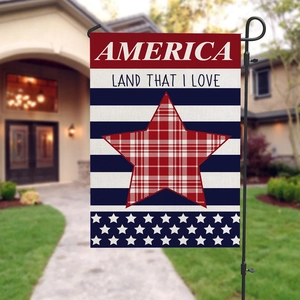 Independence Day garden flag with America star and metal stand in a green backyard