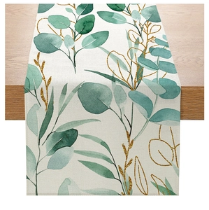 Close-up of modern polyester table runner showing green eucalyptus leaves and gold lines