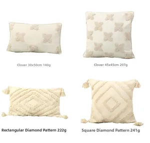 Detail of bohemian cream tufted pillow covers with geometric patterns and fringe