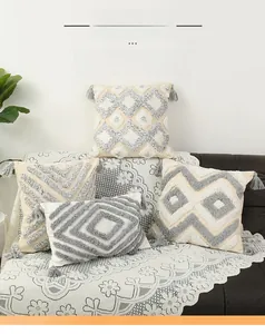 Detail of bohemian tufted pillow covers featuring geometric patterns and corner tassels