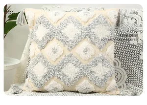 Detail of bohemian tufted cushion with grey geometric patterns and elegant tassels