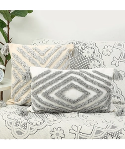 Detail of geometric tufted patterns and fringe tassels on bohemian throw pillows