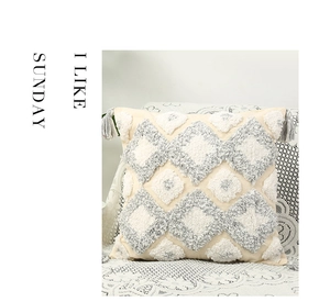 Detail of gray tufted diamond pattern and corner tassels on a Nordic boho cushion cover