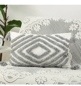 Detail of Nordic tufted lumbar pillow featuring grey geometric diamonds and corner tassels