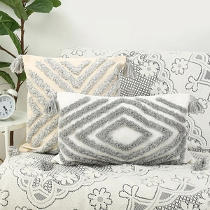 Bohemian tufted cushion covers with tassels on a white lace sofa in a cozy home setting