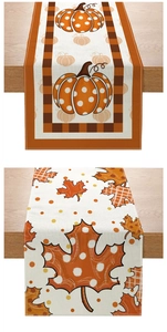 Detail of autumn table runner showing pumpkin print texture and stitched edge on wood table