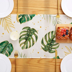 Chemin de table nordique avec imprimé de feuilles de monstera sur une table en bois