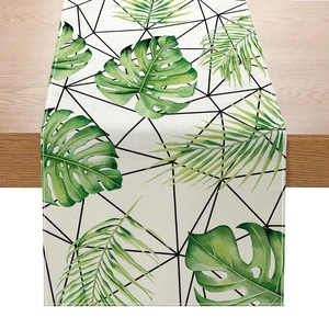 Chemin de table nordique avec feuilles tropicales et grille noire sur surface en bois