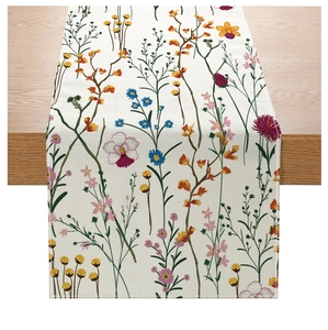Detail of floral polyester table runner with wildflower print on rustic wood surface
