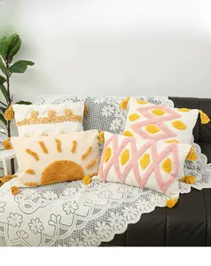 Close-up of tufted geometric patterns and fringe tassels on bohemian throw pillow cases
