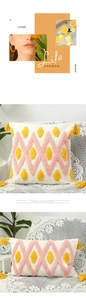 Detail of bohemian tufted cushion with pink waves and yellow tassels on sofa