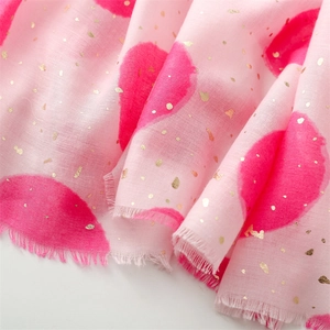 Detail of pink cotton linen scarf with red gold foil polka dots and frayed fringe edges