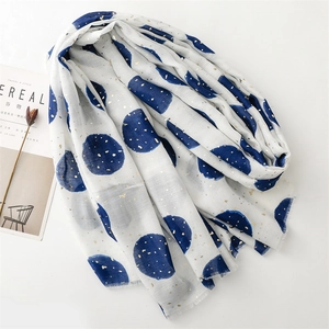 Detail of white cotton scarf with large navy polka dots and gold foil printing accents