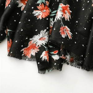 Detail of floral black cotton-linen scarf with gold foil dots and frayed edges
