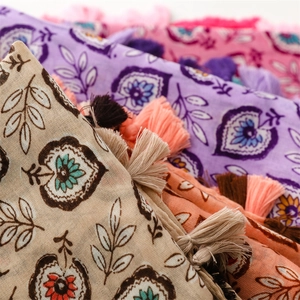 Détail de foulards à imprimé floral avec des franges douces en diverses couleurs pastel