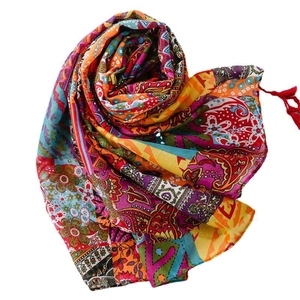 Bohemian paisley print scarf with red tassels folded into a heart shape on white background