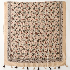 Détail d'une écharpe effet lin avec imprimés de feuilles et finitions à franges