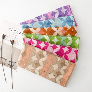 Detail of cotton-linen scarves featuring geometric star prints and metallic gold threads