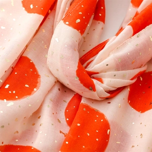 Detail of light pink scarf with orange polka dots and golden foil shimmer effect