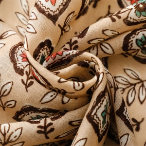 Détail macro d'une écharpe en coton et lin respirante avec motifs floraux vintage