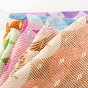 Detail showing gold foil diamond patterns and raw edges on a colorful cotton linen scarf