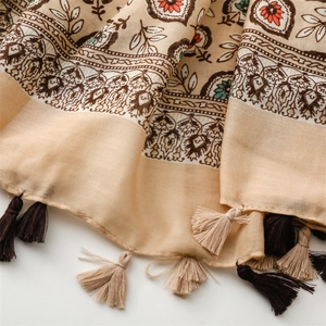 Gros plan sur le motif floral bohème d'une écharpe en coton avec détails de franges