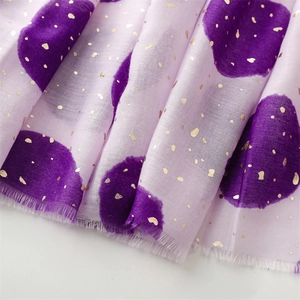 Detail of pink cotton-linen scarf featuring gold foil polka dots and raw fringe edges