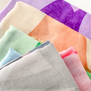 Detail of lightweight cotton linen scarf showing colorful geometric fabric and frayed edges