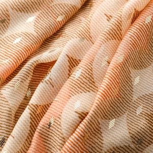 Detail showing orange wave pattern cotton linen scarf with gold foil geometric print