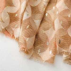 Detailed macro view of woven scarf fabric with gold geometric patterns and fringe