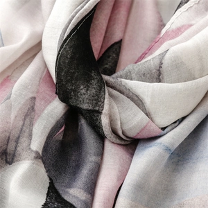 Macro detail of lightweight scarf fabric with abstract pink floral print and fine stitching