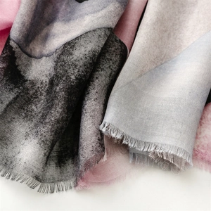 Detail of soft abstract ink wash pattern scarf with delicate raw fringe edges