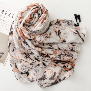 Close-up of floral print linen-feel scarf with black tassel edges and soft texture