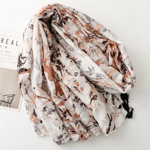 Abstract floral print scarf with black tassels on minimalist cream base backdrop