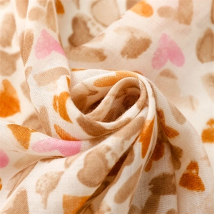 Détail macro du tissu respirant en coton et lin avec des motifs de cœurs roses et orange