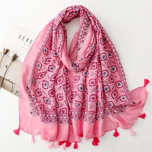 Écharpe effet lin rose avec motifs floraux et pompons sur fond blanc minimaliste