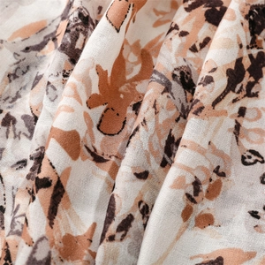 Close-up of lightweight cotton scarf with vintage graffiti pattern and soft fringe texture
