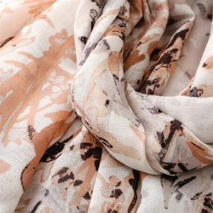 Close-up of retro graffiti print scarf showing soft cotton-linen texture and orange patterns