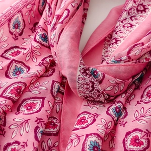 Gros plan du motif ethnique de fleurs de coquillages roses sur une écharpe en coton