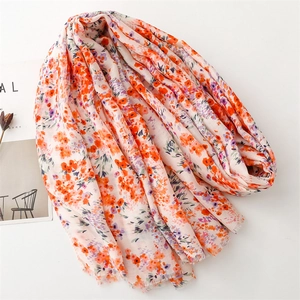 Gros plan d'une écharpe florale aux motifs orange et violet avec des bords effilés