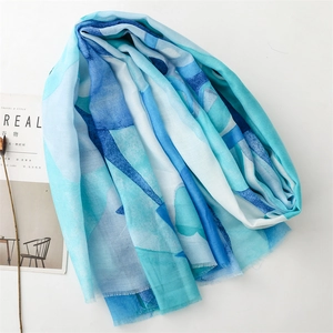 Close-up of lightweight blue gradient scarf with raw edges and soft linen texture