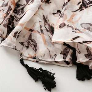 Close-up of retro scarf detail showing soft fabric texture, bird print, and black tassels