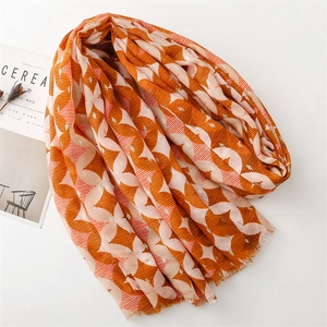 Detail of clover patterns with gold thread accents and fringe on a cotton-linen scarf