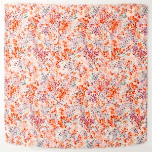 Détail d'une écharpe légère à imprimé floral orange et rouge avec bordures effilochées