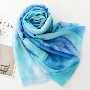 Detail of blue watercolor gradient scarf featuring soft cotton-linen feel and raw frayed edges