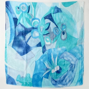 Detailed view of the frayed edge and floral watercolor print on lightweight blue scarf